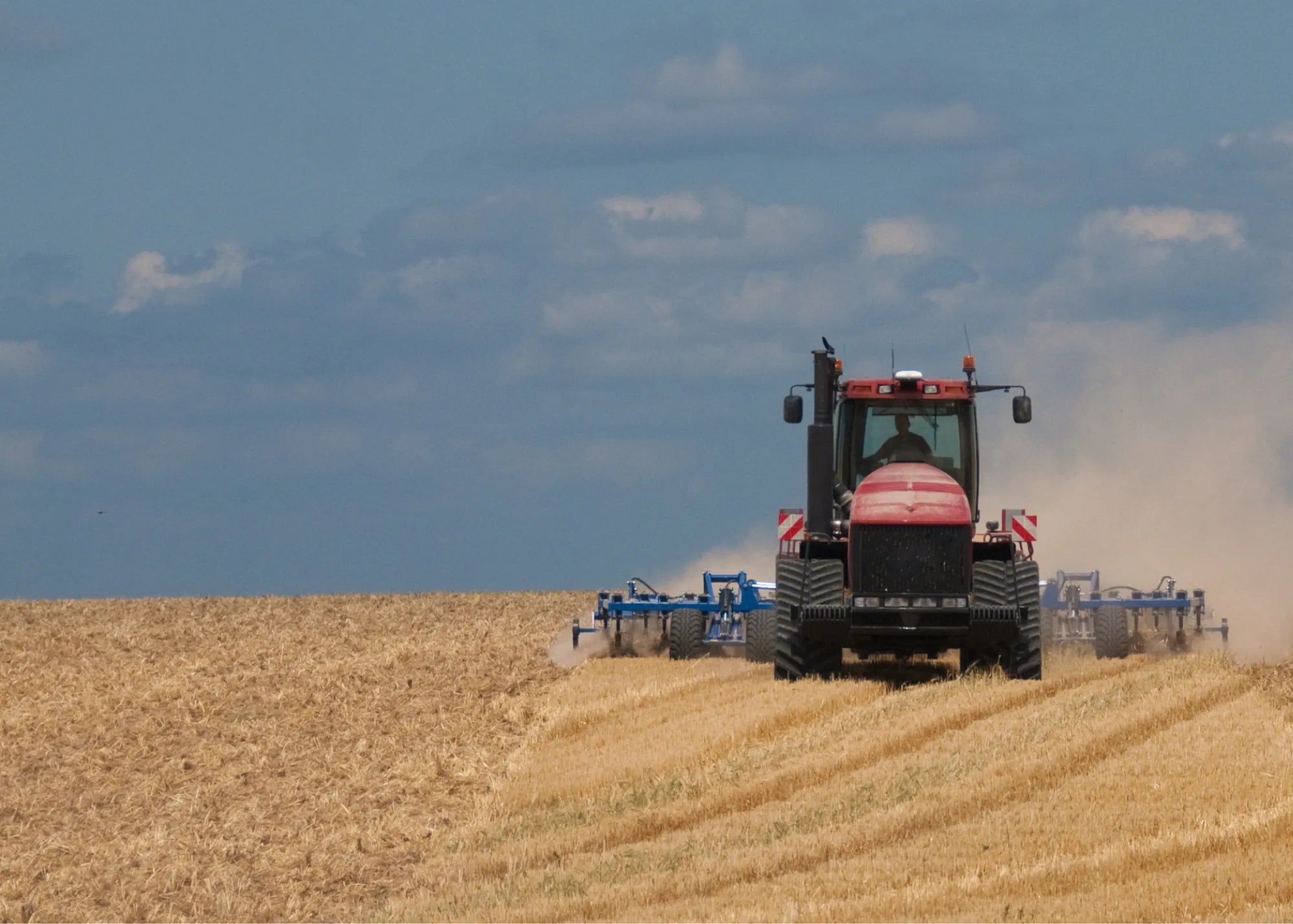 Red Case IH Quadtrac tracked tractor in a field, used farm machinery, Les Équipements Daigle