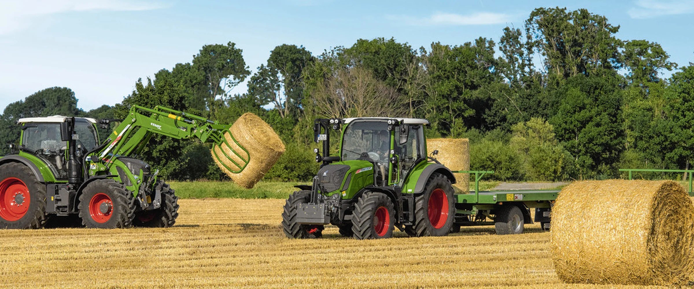 Tracteur Fendt à jantes rouges avec chargeur frontal dans une ferme