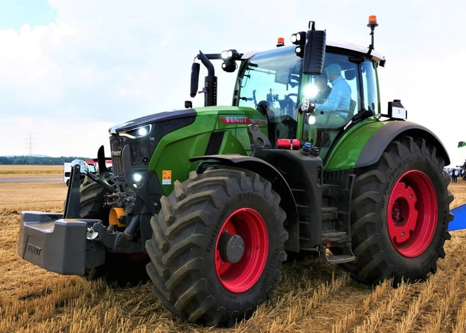 Tracteur Fendt tirant une remorque de bois sur la route