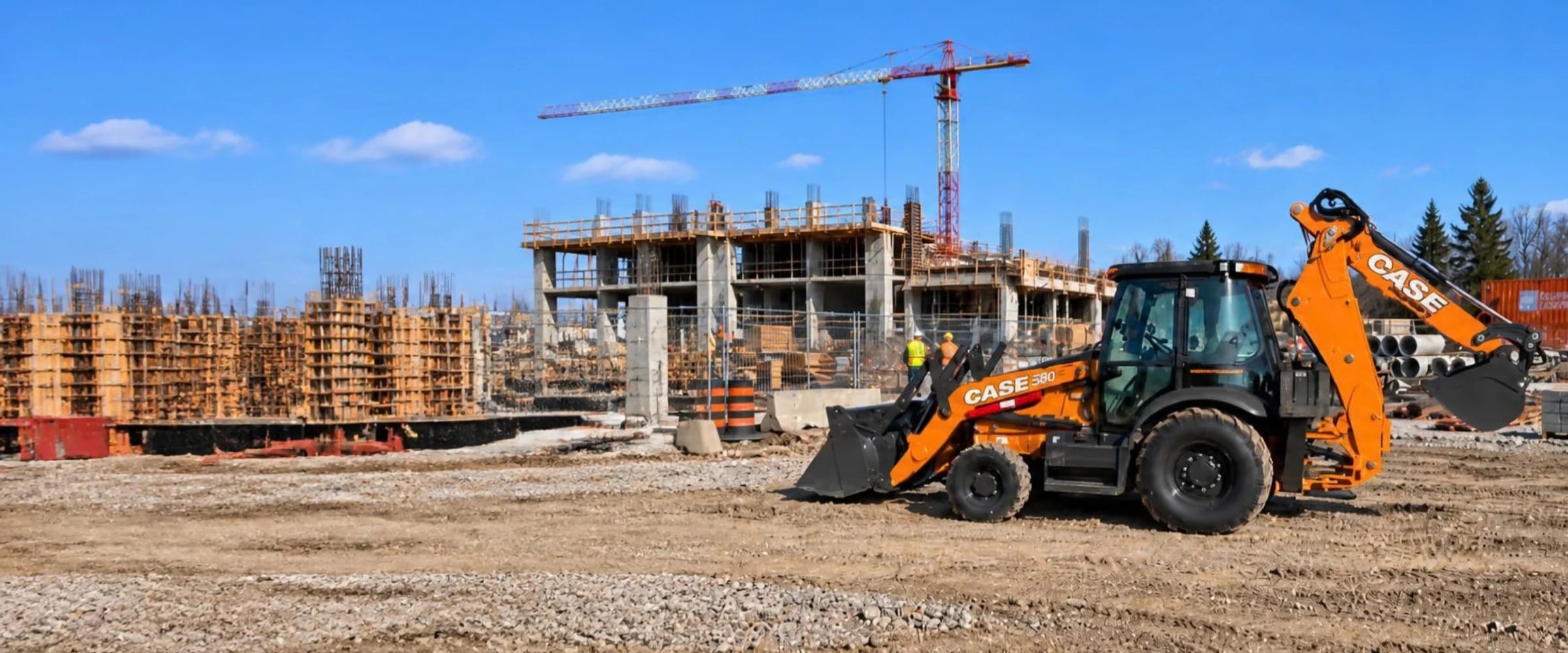 Chargeuse-rétrocaveuse Case 580 sur un chantier de construction avec grue