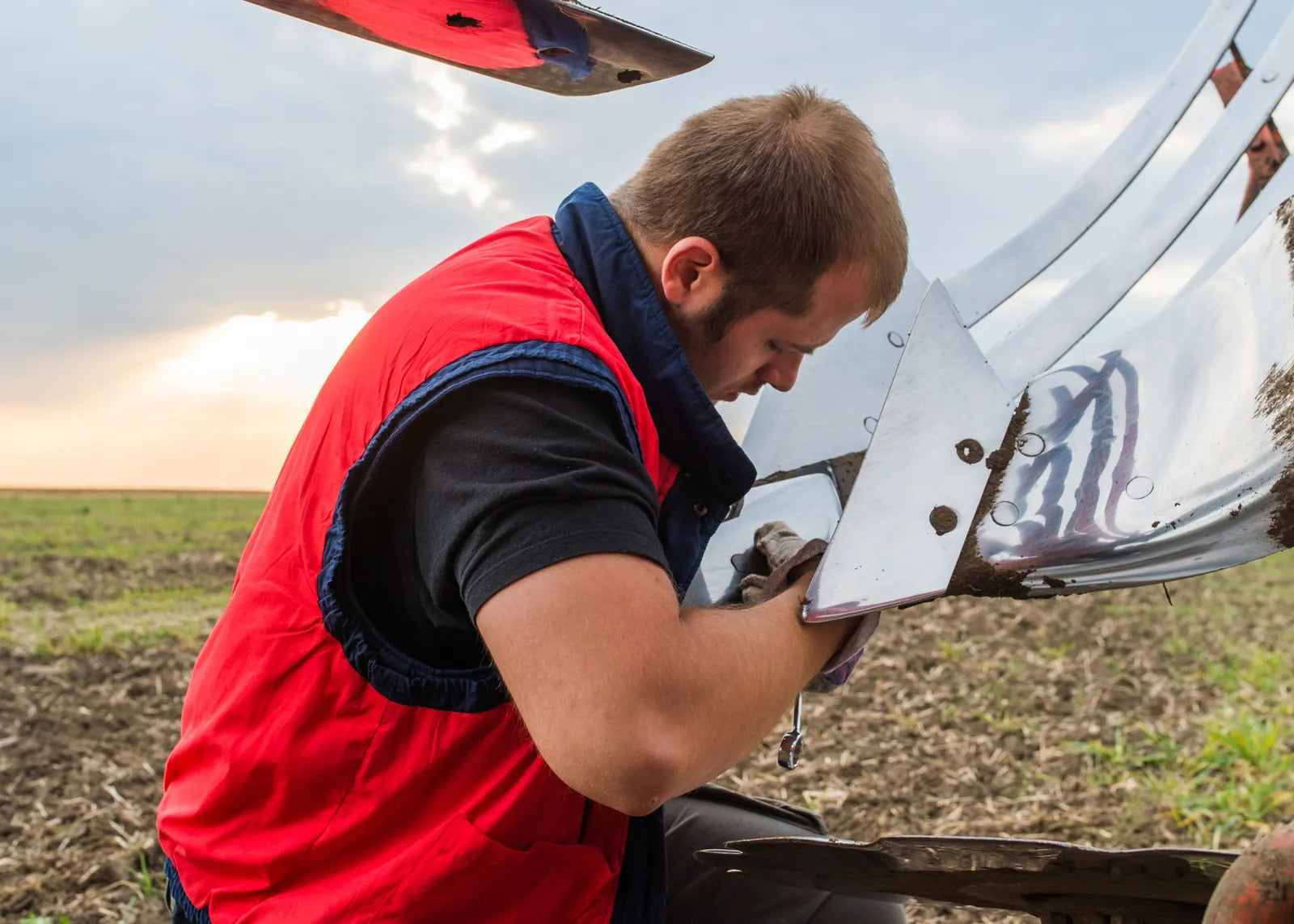 Équipements Daigle mechanic inspecting a used farm machine