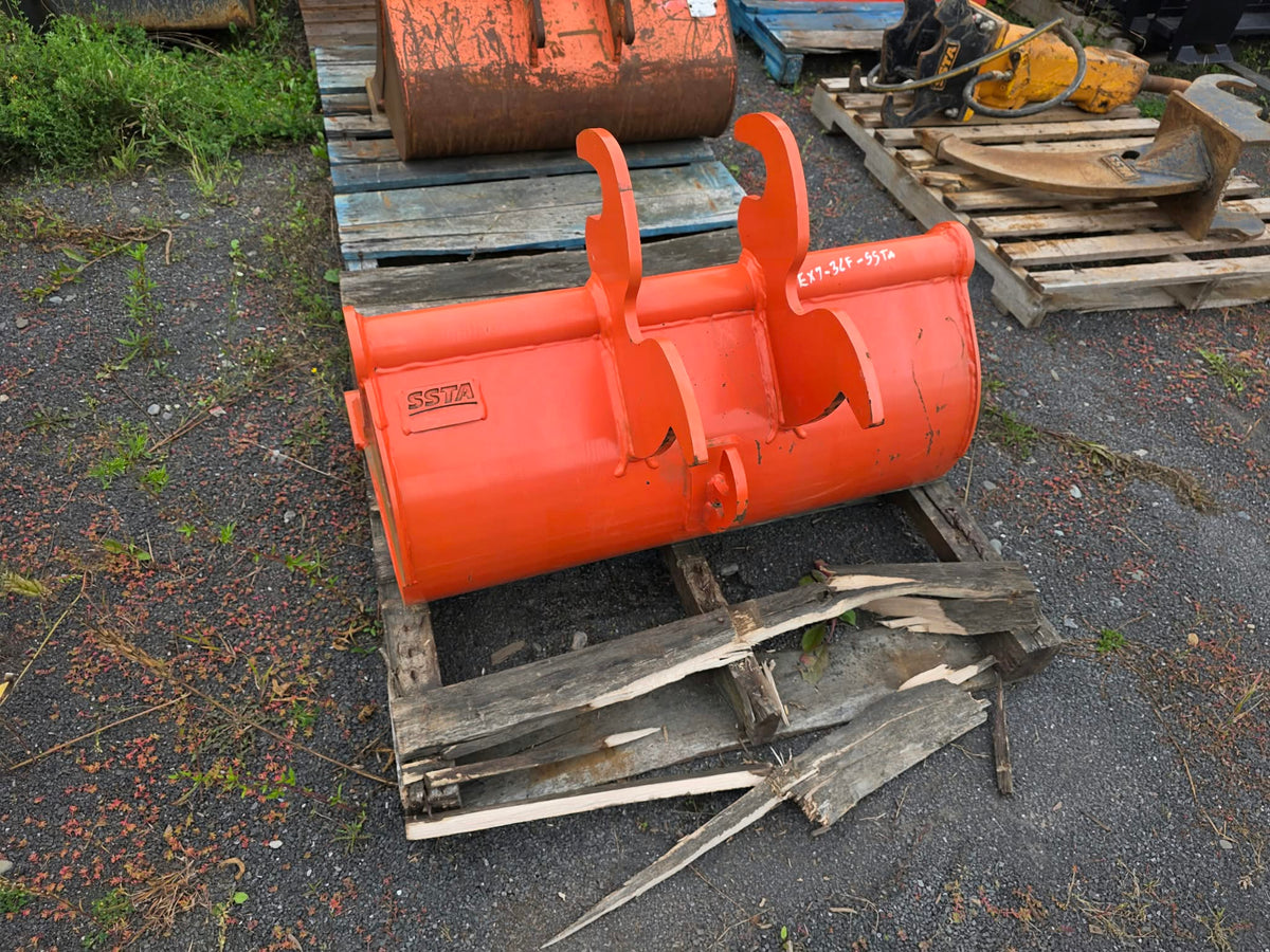 Bucket SSTA 36'' godet orange usagé, vue arrière montrant les attaches d'attelage sur palette