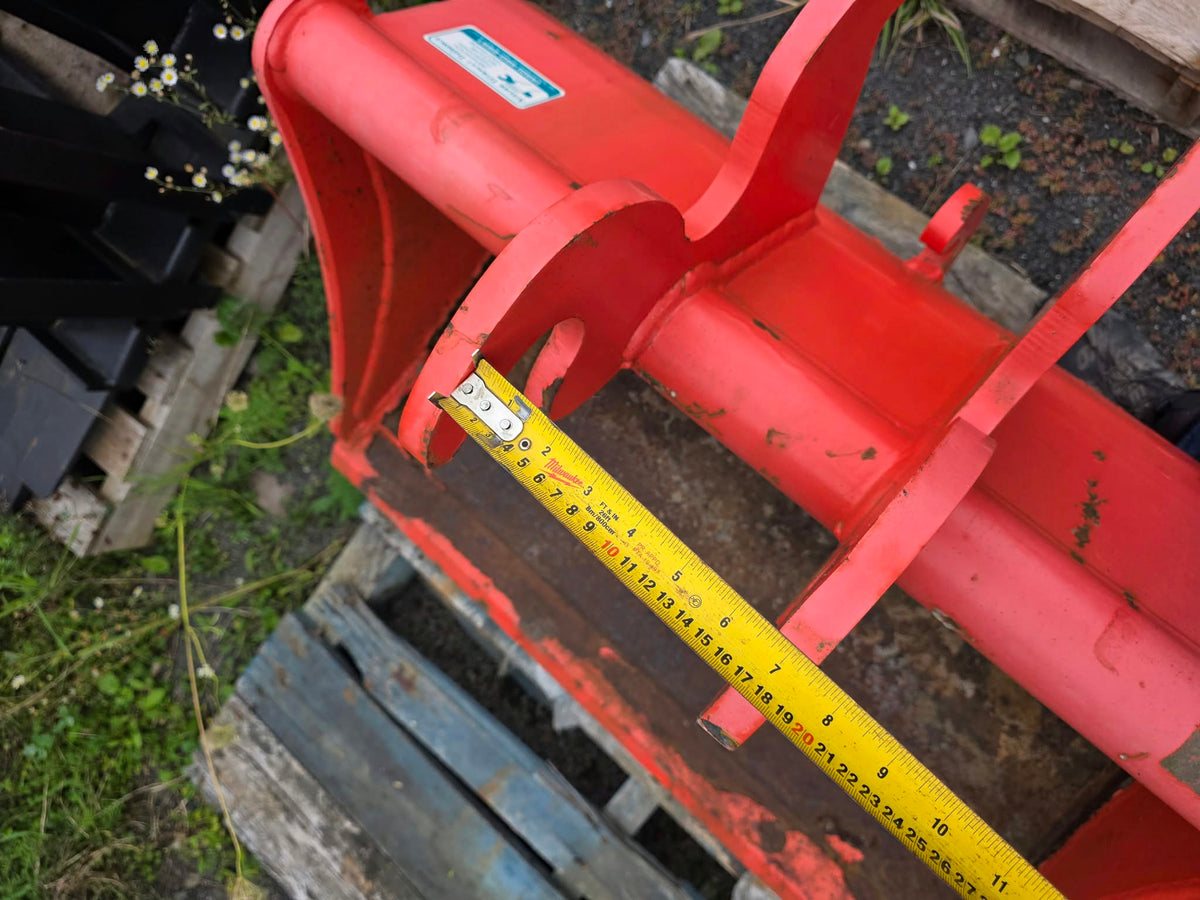 Bucket Tétreault 36po, vue rapprochée des oreilles d'attelage avec ruban à mesurer sur la largeur
