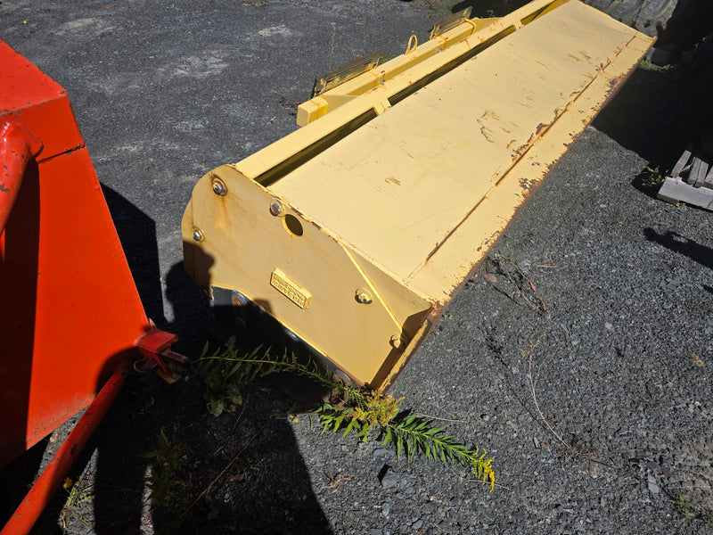 Gratte à neige Cotech 92po, vue de biais montrant la lame jaune et plaque d'attache déposée au sol