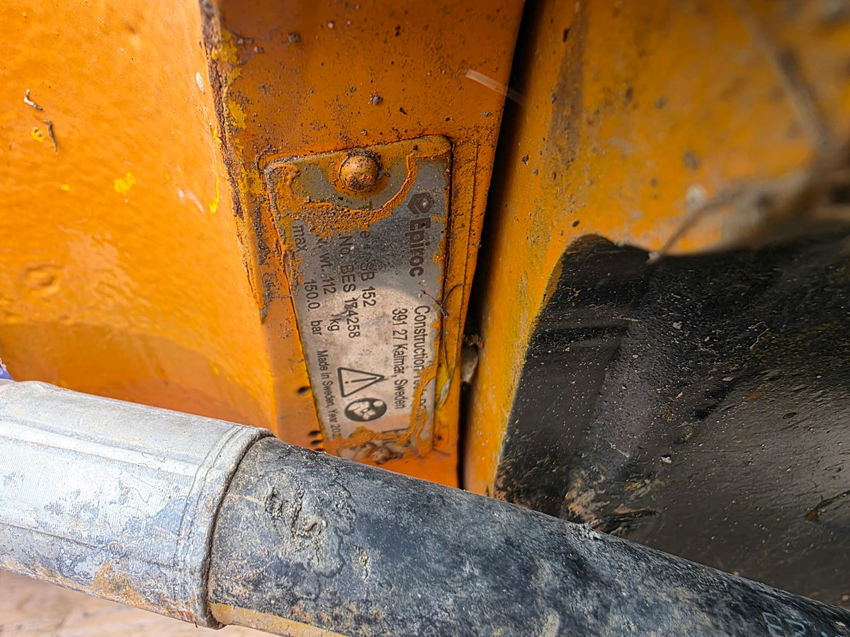 Marteau piqueur Epiroc Bes174258 2023 gros plan plaque signalétique SB 152 fixée sur boîtier orange