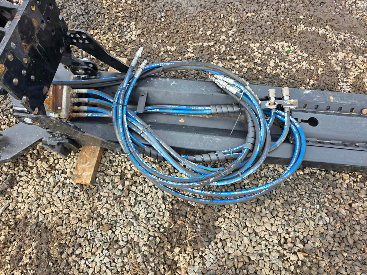 Harnais relevage avant avec sortie d'huile, vue des boyaux hydrauliques enroulés sur le châssis