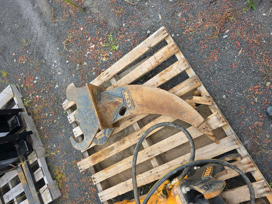 Ripper Ssta pour pelle de 3.5T vue de dessus déposé sur palette de bois, dent et attache visibles
