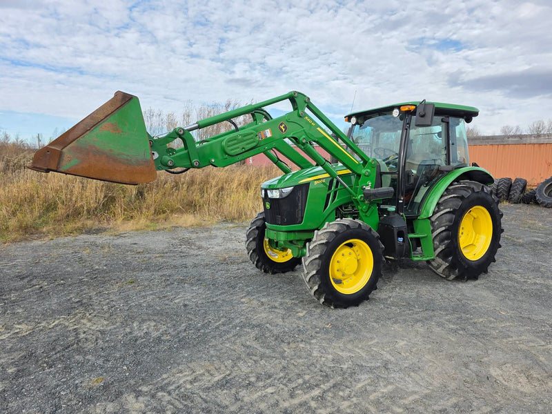 John Deere 5100e vue de profil, chargeur 540M levé avec godet, cabine et pneus jaunes visibles
