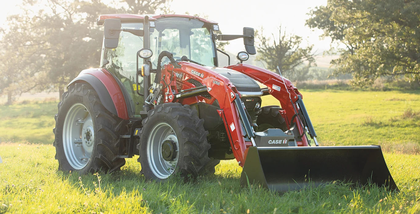 Tracteur Case IH Farmall rouge avec chargeur frontal L635 dans un pré ensoleillé