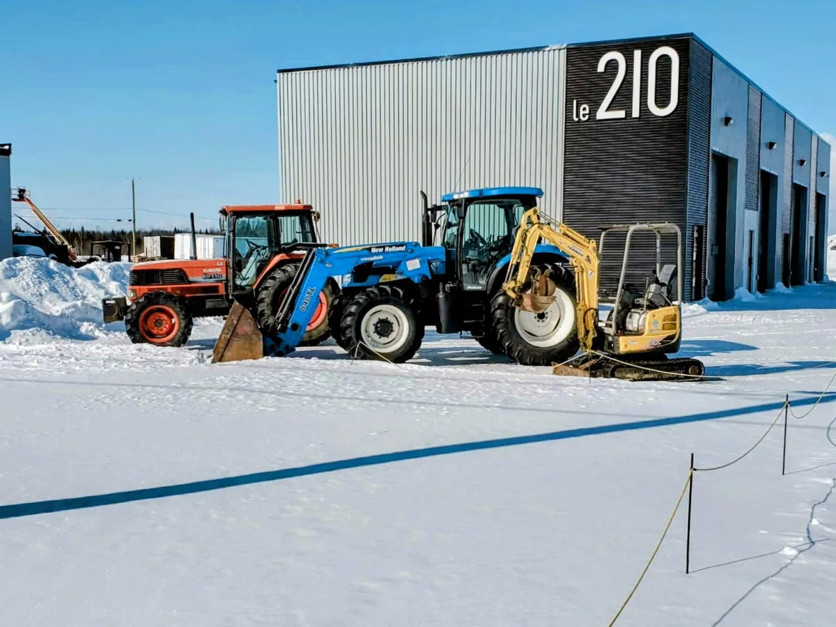 Bâtiment des Équipements Daigle à Issoudun en hiver, avec tracteurs et souffleur