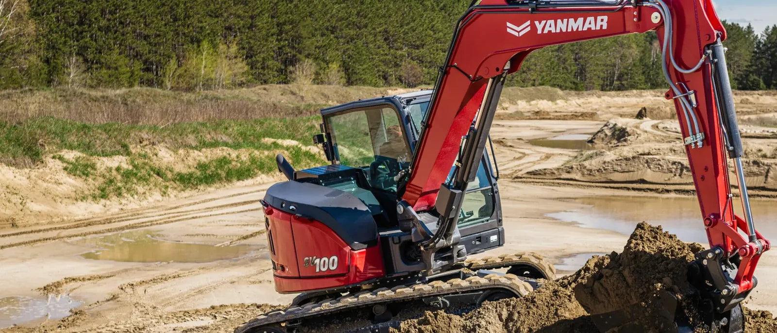 Excavatrice Yanmar ViO100 rouge creusant dans une sablière
