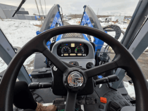 Vue depuis le poste de conduite du tracteur New Holland T6.155 2019 avec volant et tableau de bord