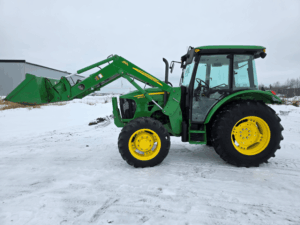 Vue latérale du tracteur John Deere 5083E usagé avec chargeur frontal 563 en vente au Québec