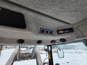 Vue détaillée du montant de cabine et des commandes auxiliaires du tracteur Massey Ferguson 5460 usagé, année 2012, disponible chez Les Équipements Daigle au Québec. Cette image met en évidence les interrupteurs de fonctions, les commandes de prise de force (PTO) et l’agencement ergonomique de la cabine, offrant une utilisation simple et efficace au quotidien. Ce tracteur agricole affiche 4 899 heures, est bien entretenu et prêt à travailler. Prix demandé : 51 500 $.