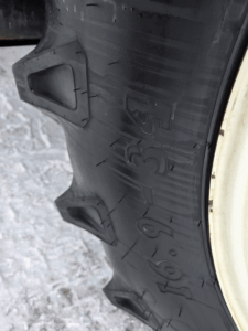 Pneu arrière agricole 16.9-34 du tracteur New Holland T5.95 en bon état