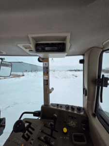 Operator view inside John Deere 7330 cab with steering wheel and pedals – used tractor