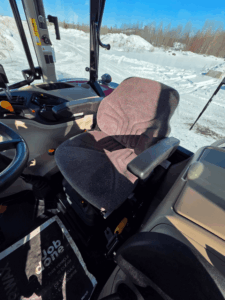 Massey Ferguson 4707 operator seat with armrests and glass cab