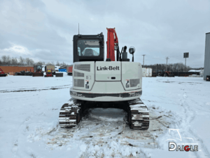 Vue complète de l’excavatrice Link-Belt 75X3 avec plusieurs godets et une lame avant, prête pour différents types de travaux sur chantier.