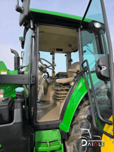Complete view of the John Deere 6110M highlighting the cab, tires, and loader.