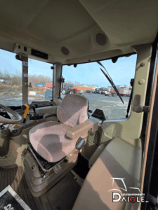 Interior view of the John Deere 6110M cab showing the seat, controls, and operator station.