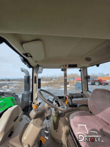Cab of the John Deere 6110M featuring an ergonomic operator seat offering comfort and visibility.