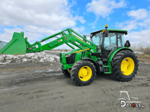 Tracteur John Deere 5115M avec chargeur frontal en position levée sur terrain