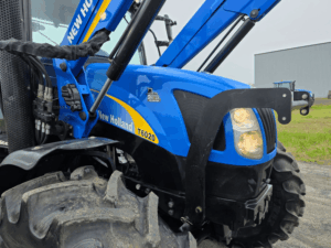 Gros plan sur le capot avant et le pneu du tracteur New Holland T6020.