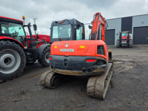Rear view of a 2019 Kubota KX080-4SG excavator with enclosed cab and steel tracks.