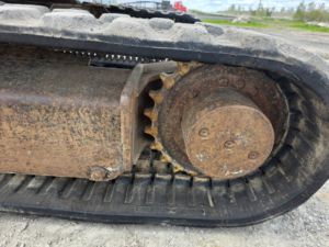 Drive sprocket and rubber track on Caterpillar 303.5E CR excavator.