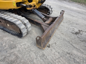 Front blade on Caterpillar 303.5E CR excavator used for grading work.