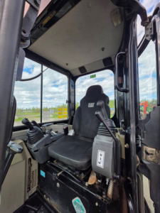 Operator seat and controls inside the 2012 Caterpillar 303.5E CR excavator.