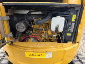 Engine compartment of Caterpillar 303.5E CR excavator opened for inspection.