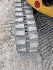 Chenille excavatrice Caterpillar 303.5E CR montrant l’usure des crampons.