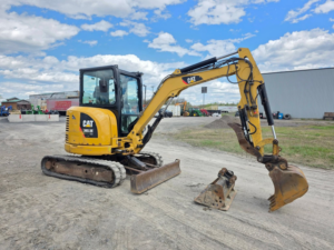 Caterpillar 303.5E CR excavator with trenching bucket and hydraulic quick coupler.