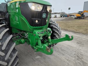Front hitch of the John Deere 6155R tractor with agricultural attachment.