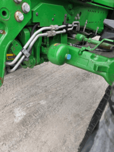 Front hydraulic components of the John Deere 6155R tractor.