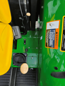 Operator console and cup holder on a John Deere 5075E tractor.