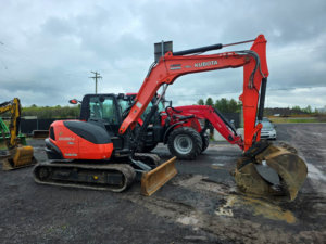 Excavatrice Kubota KX080-4SG 2019 vue de profil avec chenilles en acier et pince hydraulique.