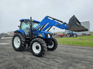 Front angled view of the New Holland T6020 tractor with raised loader bucket.