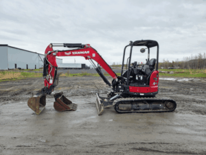 Red Yanmar ViO35 compact excavator with two buckets parked at Les Équipements Daigle Inc.