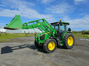 2020 John Deere 5115M tractor with raised front loader.