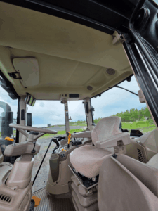 Suspension seat and operator station inside a 2020 John Deere 6110M tractor.