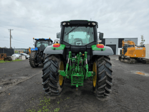 Rear view of a 2021 John Deere 6140M tractor with three-point hitch and hydraulic connections.