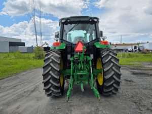 Rear view of a 2020 John Deere 6110M tractor with three-point hitch.
