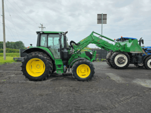 Vue latérale gauche du tracteur John Deere 6140M 2021 avec chargeur frontal John Deere et godet.