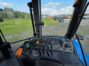 Hydraulic levers and operator controls inside the New Holland TM175 tractor.