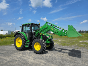 Full side view of the 2022 John Deere 6110M equipped with a John Deere 600R front loader and bucket, available at Les Équipements Daigle.